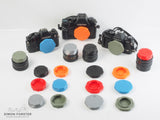 Assorted 3D-printed Contax Yashica body caps and rear lens caps in various colours for Contax Yashica mount cameras and lenses.