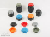 Assorted 3D-printed PK mount rear lens caps in various colors for Pentax K mount lenses By Forster UK on a white backdrop.